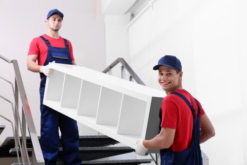 Local movers navigating stairs in a Brompton property