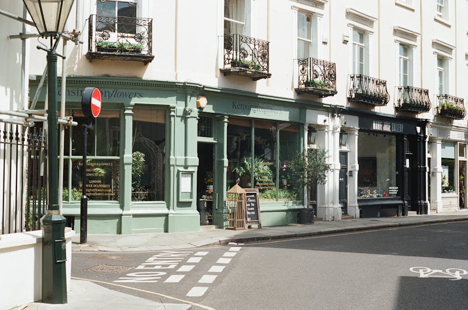 A white exterior wall of a residential property showing a street sign for Portobello Road, W.11, mounted on the wall near the corner of the building. In front of the wall, there is a small white balus